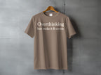 Taupe t-shirt with white text "Overthinking but make it 🌲 scenic"