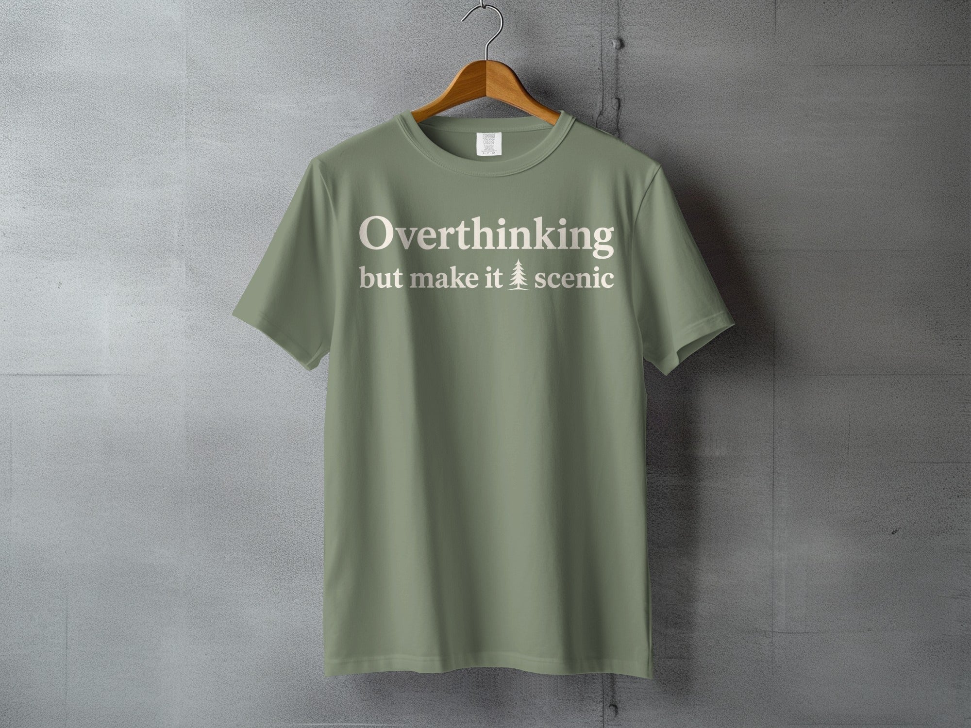 Olive t-shirt with "Overthinking but make it scenic" text and a tree graphic.