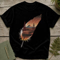 Black t-shirt with a feather graphic depicting a forest and mountain landscape.
