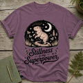 Purple t-shirt with a capybara, moon, stars, and text "Stillness is my Superpower".