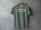 Green t-shirt with cream text "Overthinking but make it 🌲 scenic"