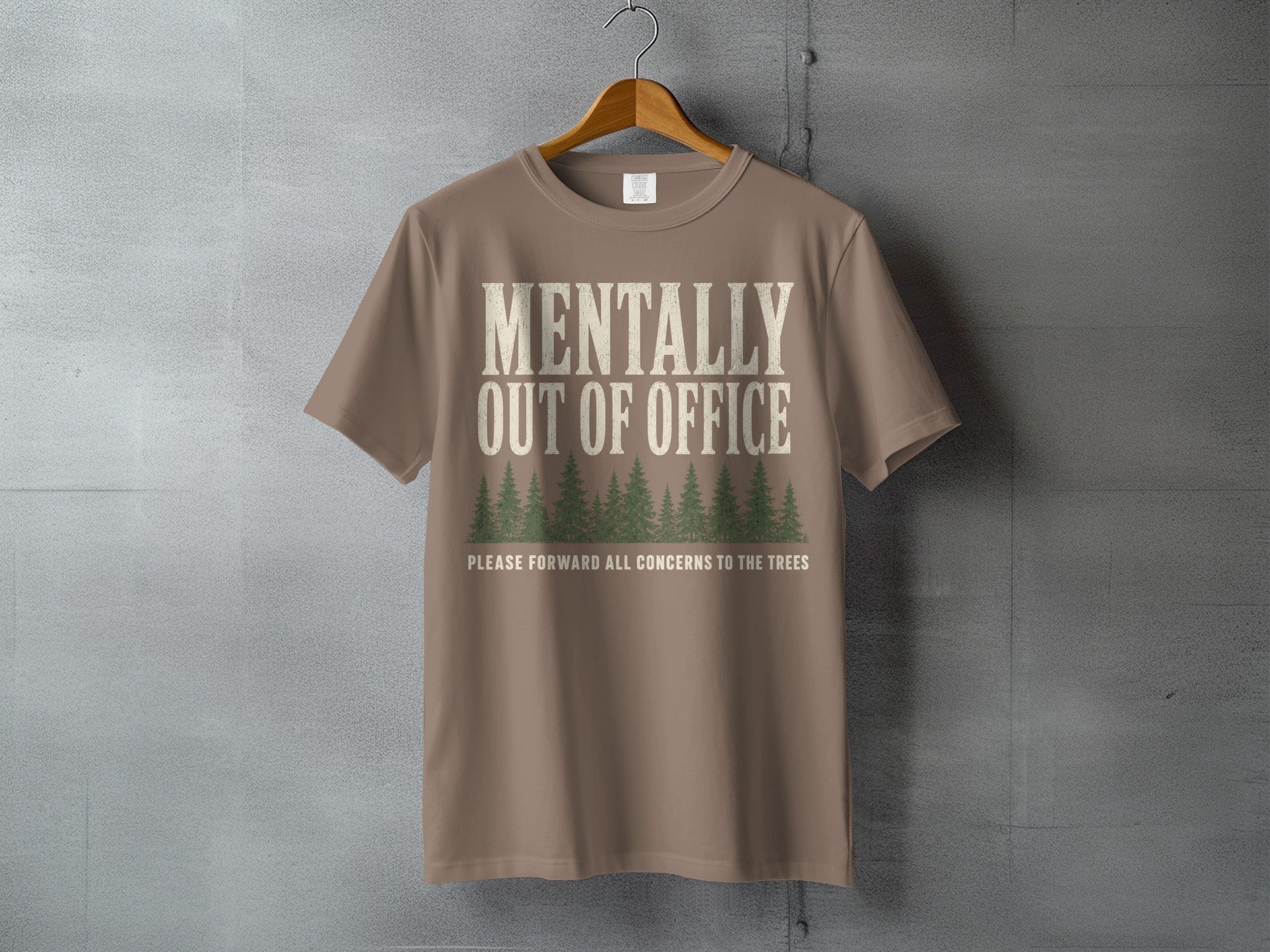 Brown t-shirt with "MENTALLY OUT OF OFFICE" and trees graphic.