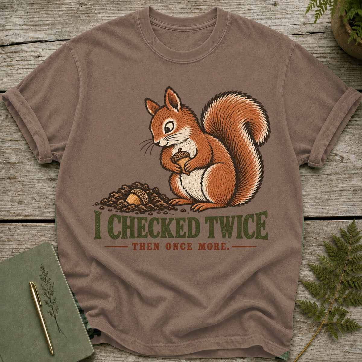 Brown t-shirt with illustration of a squirrel holding an acorn and text "I CHECKED TWICE THEN ONCE MORE."