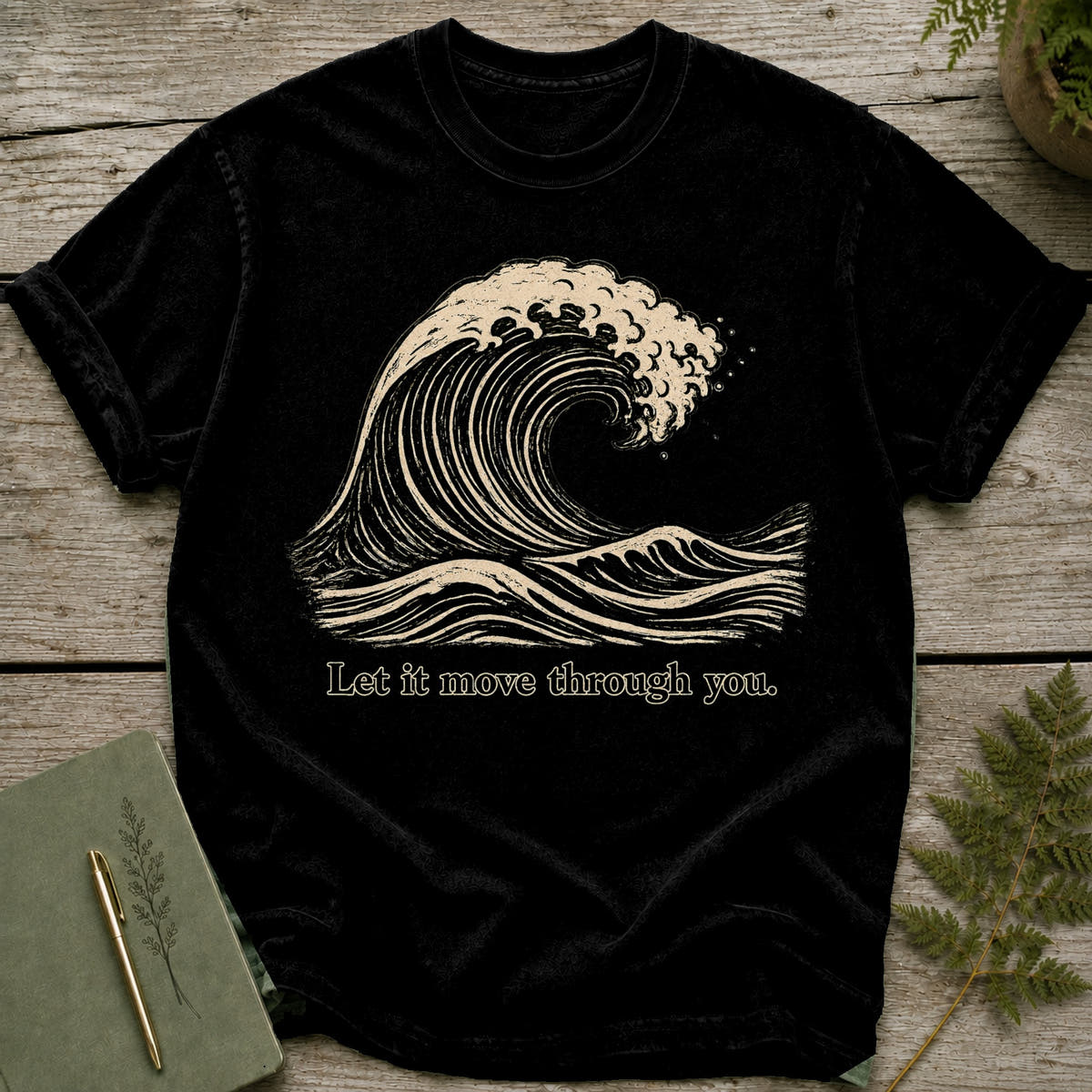 Black t-shirt with a cream wave graphic and text "Let it move through you."