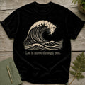 Black t-shirt with a cream wave graphic and text "Let it move through you."