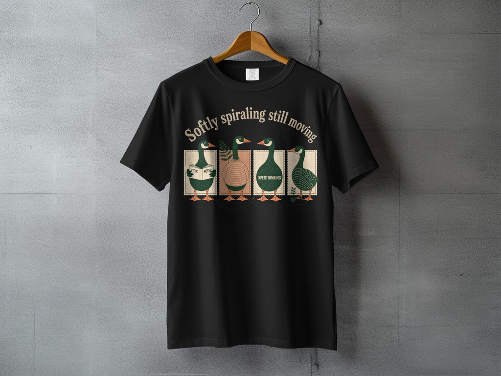 Black t-shirt with four stylized ducks and the text "Softly spiraling still moving."