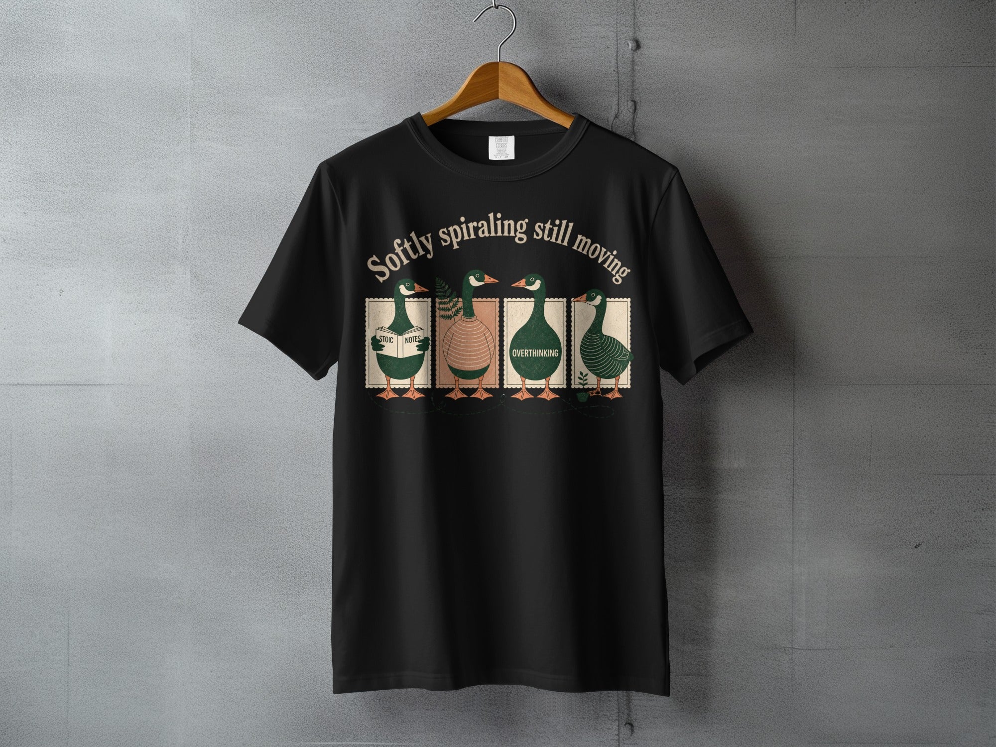 Black t-shirt with four stylized ducks and the text "Softly spiraling still moving."