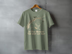 Olive green t-shirt with a graphic of a tree branch, a bird, and the text "In The Moment The Rest Can Wait."