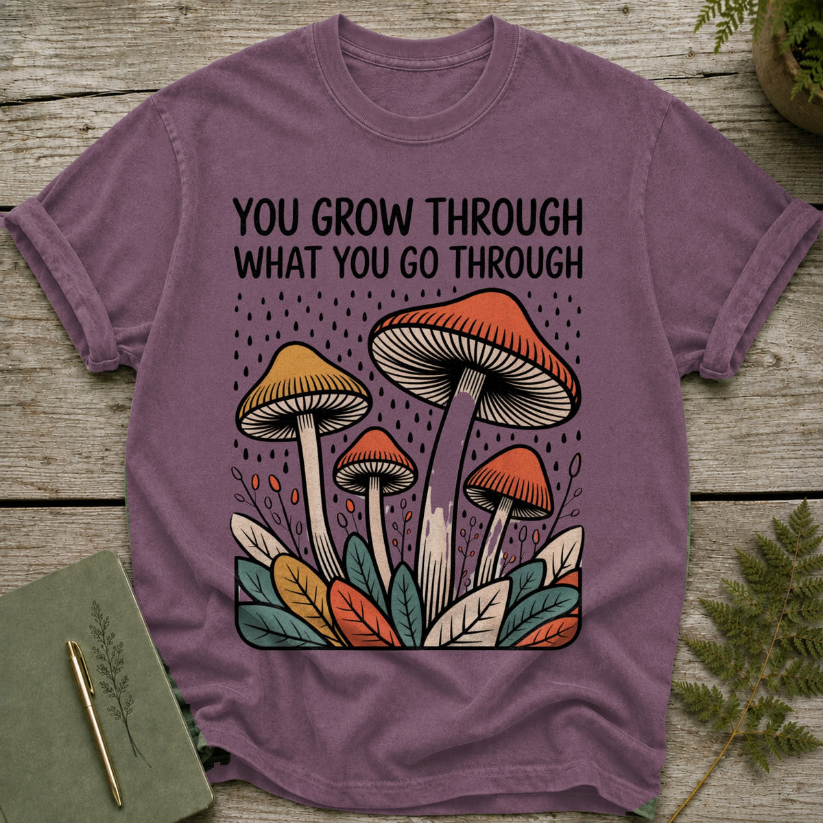 Purple t-shirt with "You grow through what you go through" text and mushroom design.