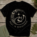 Black t-shirt with a circular design of a sleeping fox, mushrooms, butterflies, and stars.