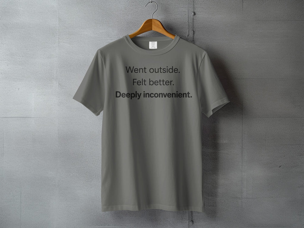 Gray t-shirt with black text reading "Went outside. Felt better. Deeply inconvenient."