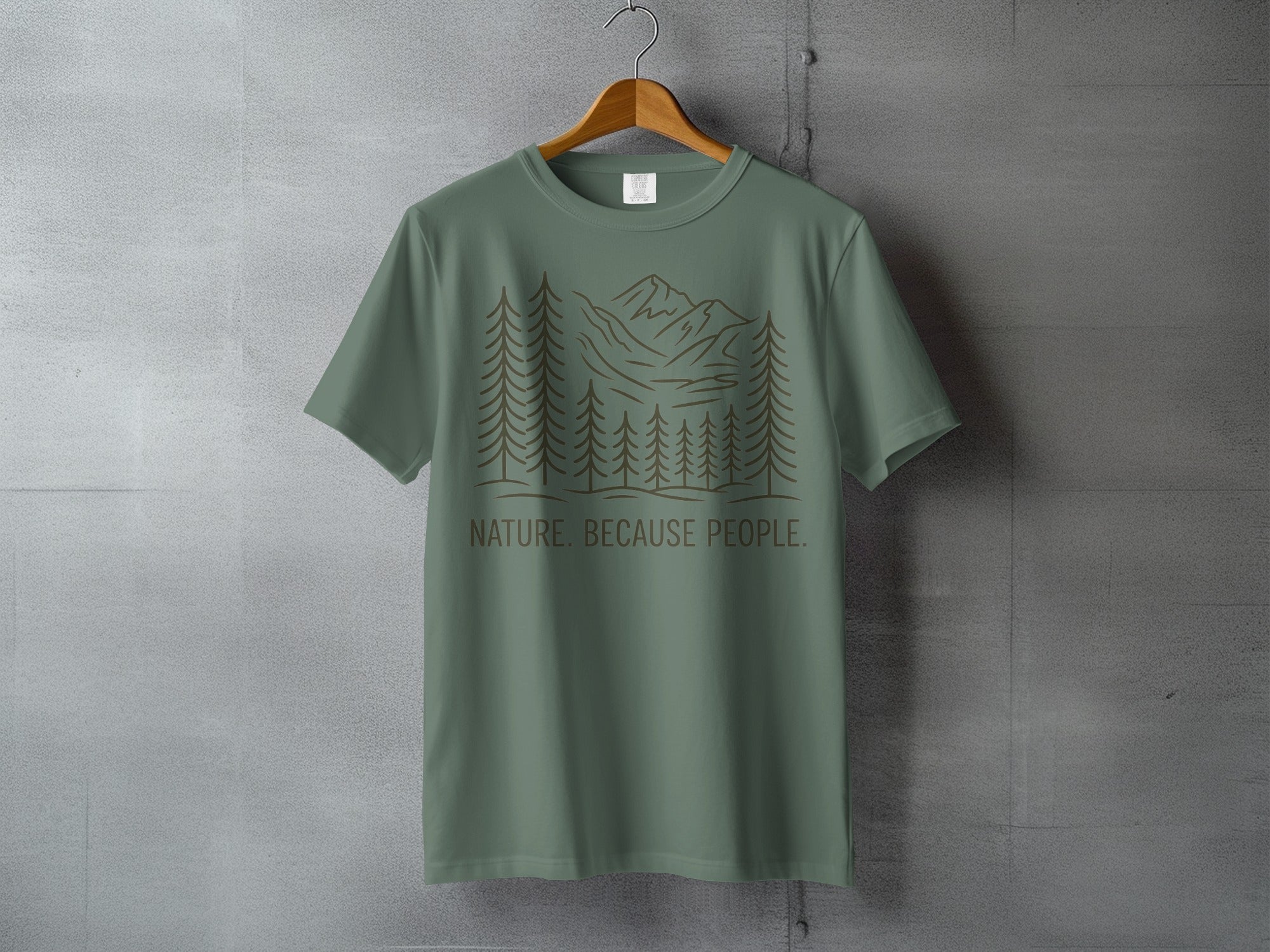 Green t-shirt with forest and mountain design and text "NATURE. BECAUSE PEOPLE."