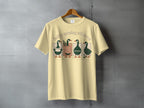 T-shirt with four ducks and text "Softly spiraling still moving".