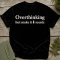 Black t-shirt with white text "Overthinking but make it scenic" and a small tree graphic.