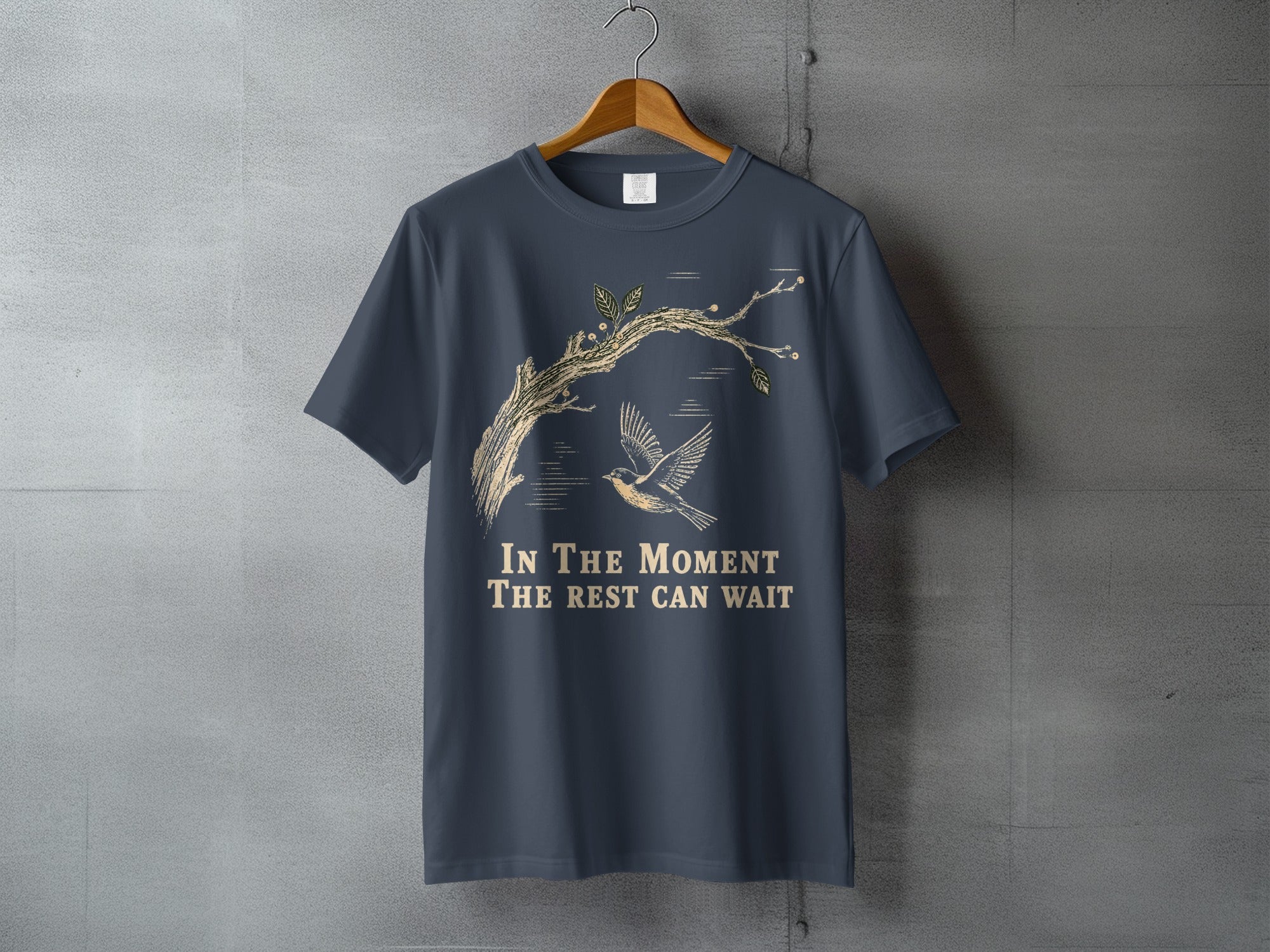 Dark blue t-shirt with a tree branch, bird, and the text "In The Moment The Rest Can Wait".