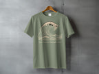Olive green t-shirt with a wave graphic and text reading "Let it move through you."