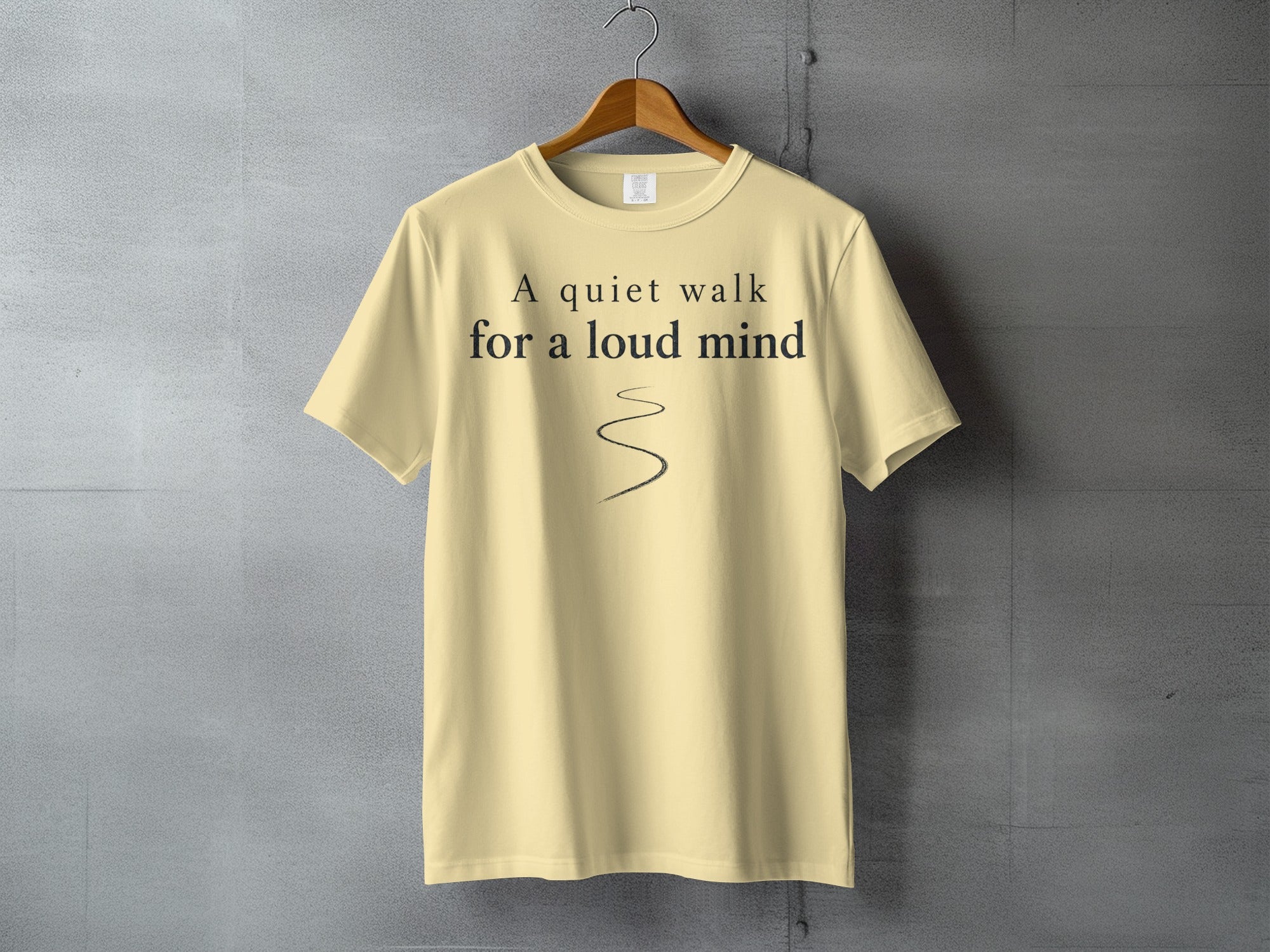 Light yellow t-shirt with "A quiet walk for a loud mind" text and wavy line.
