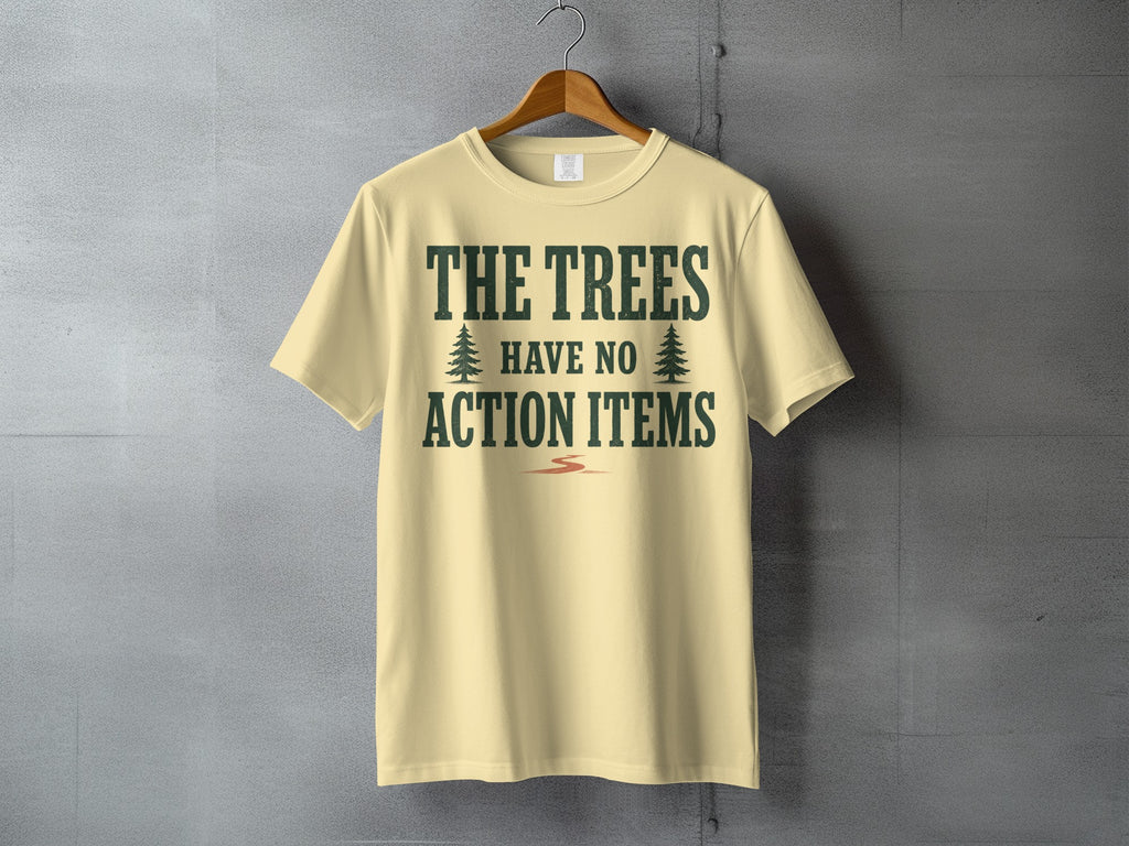 Light yellow t-shirt with dark green text reading "THE TREES HAVE NO ACTION ITEMS".