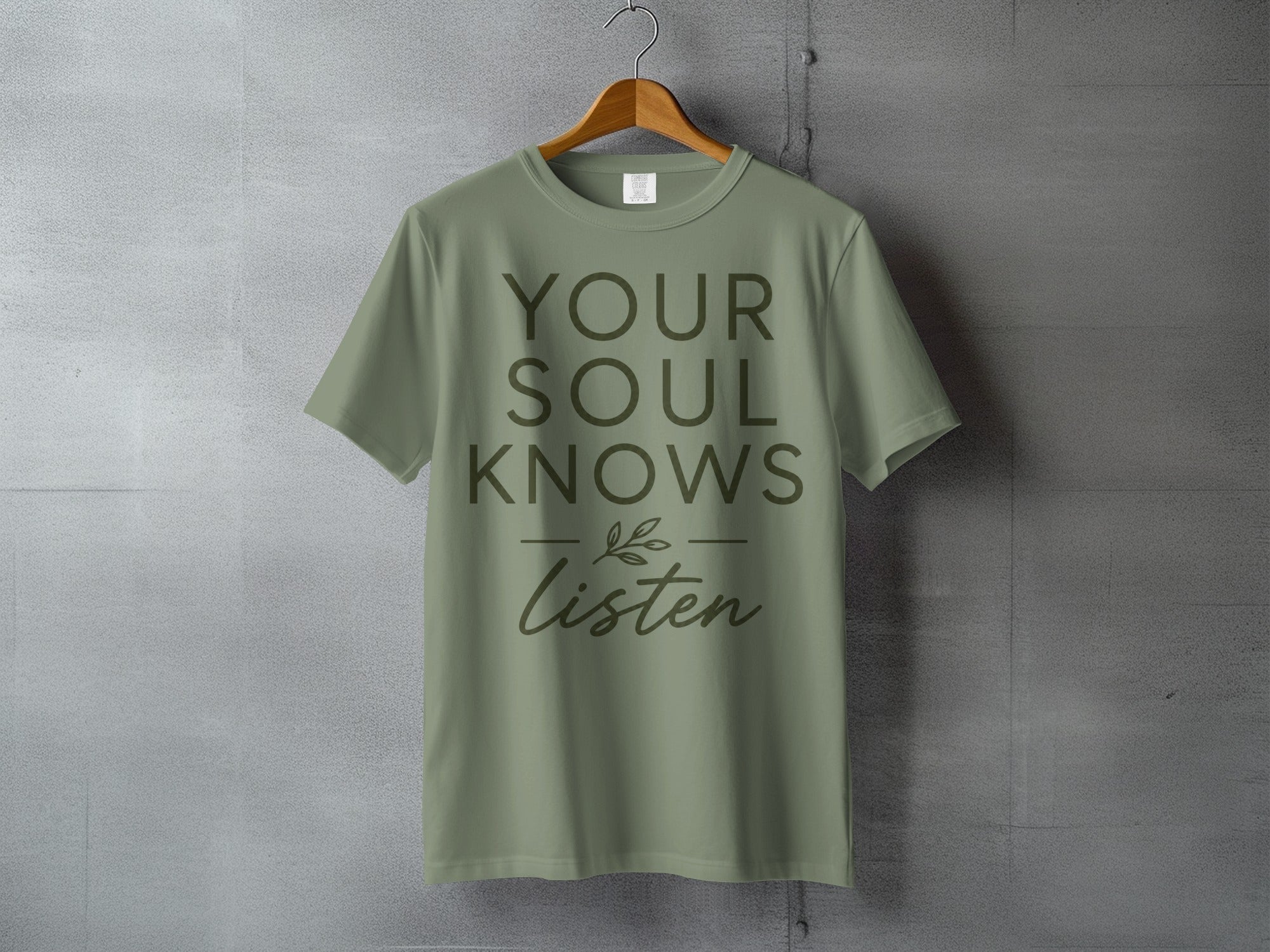 Olive green t-shirt with "YOUR SOUL KNOWS Listen" text and a leafy sprig design.