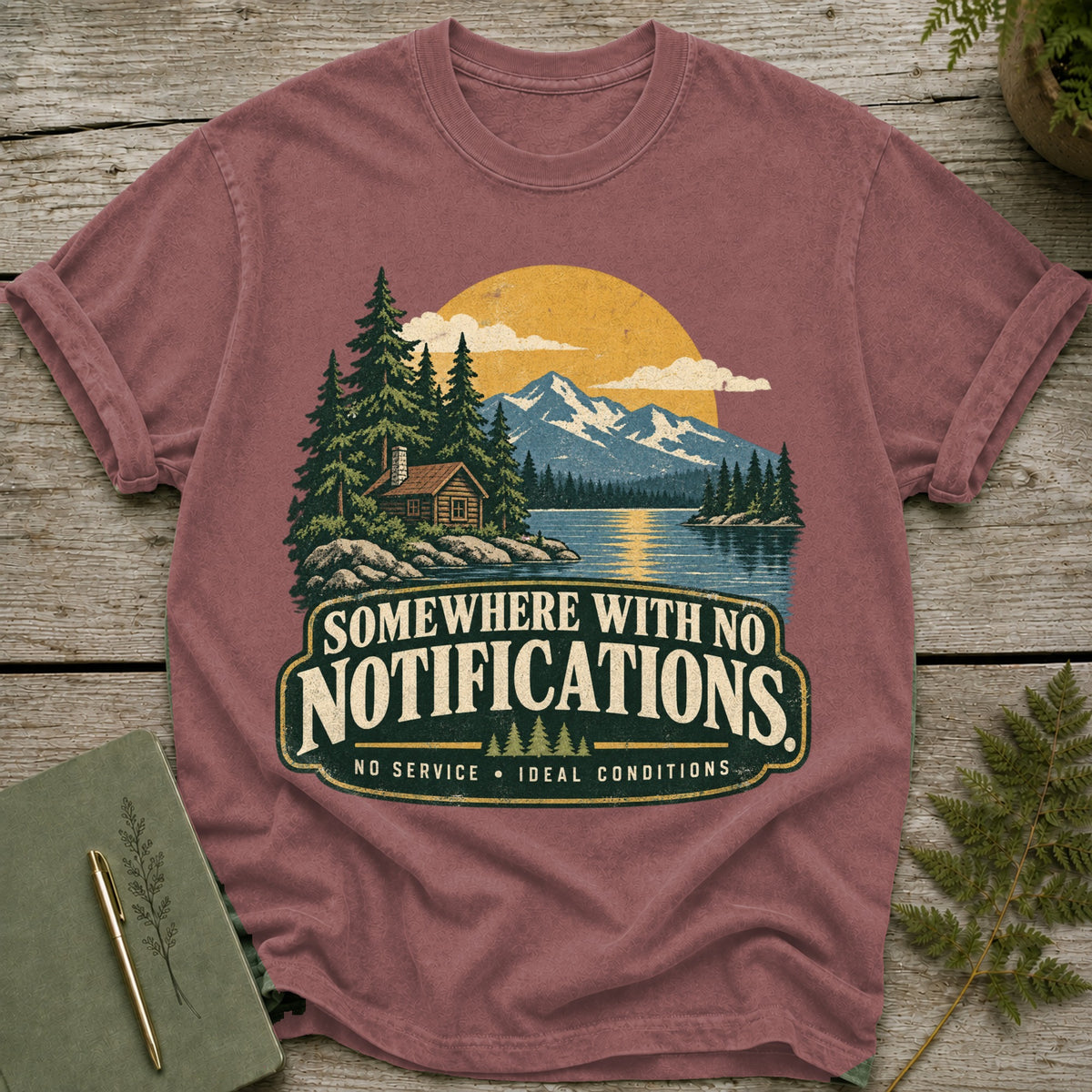 T-shirt with "Somewhere With No Notifications" text and a cabin in a mountain lake scene.
