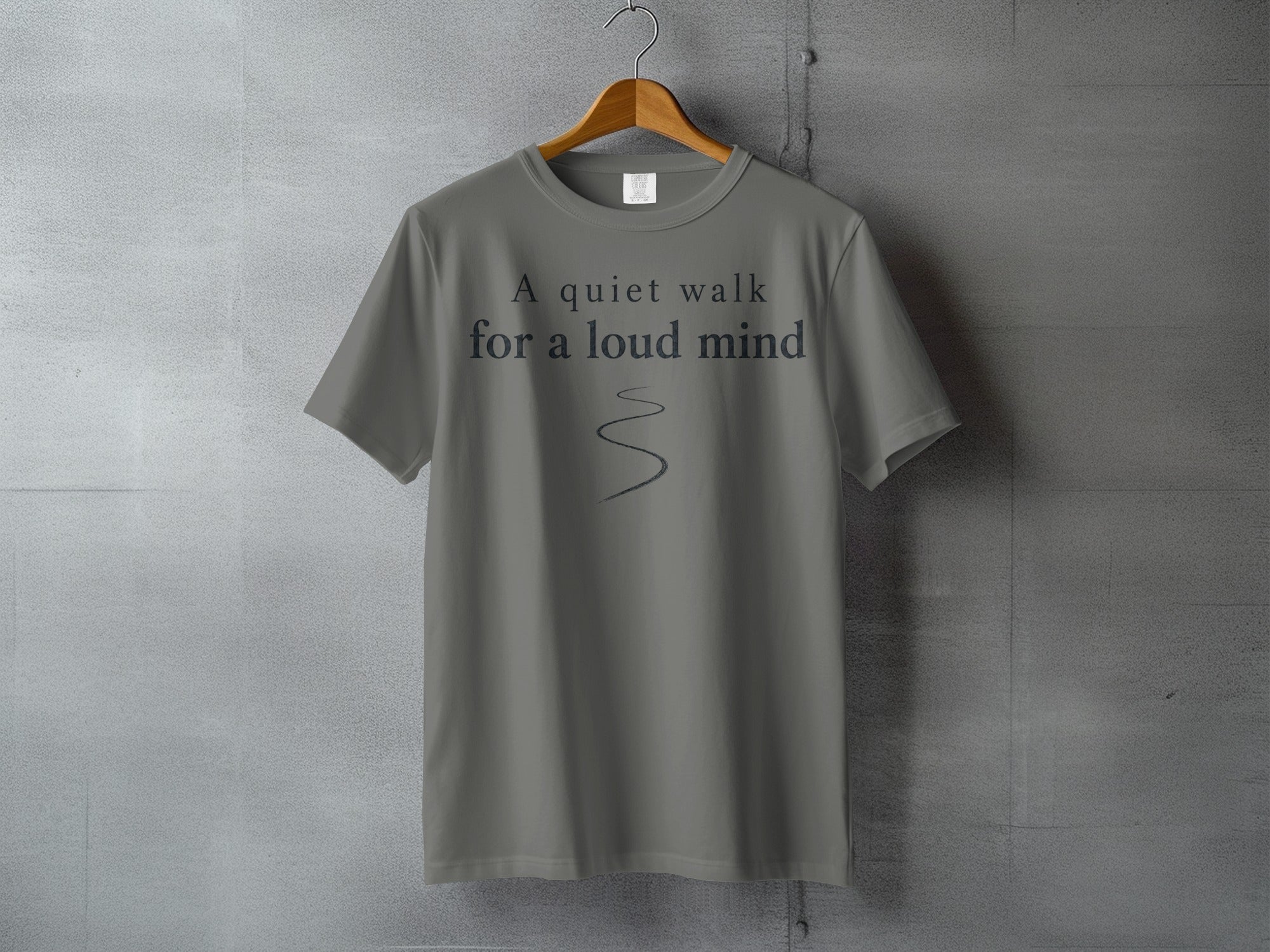 Gray t-shirt with "A quiet walk for a loud mind" text and a curved line.