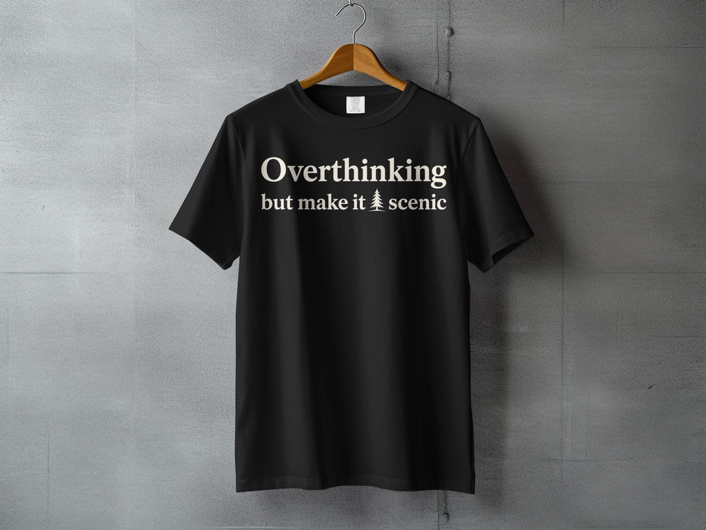Black t-shirt with text "Overthinking but make it scenic" and a tree icon.