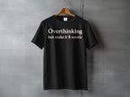 Black t-shirt with text "Overthinking but make it scenic" and a tree icon.