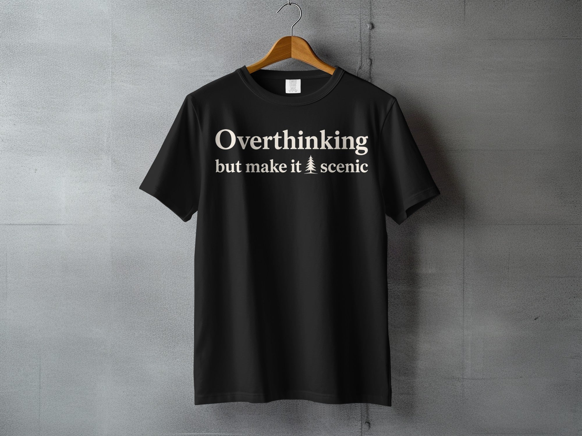 Black t-shirt with text "Overthinking but make it scenic" and a tree icon.