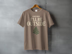 Brown t-shirt with "PLEASE ADVISE I'LL BE OUTSIDE" text and fern graphic.