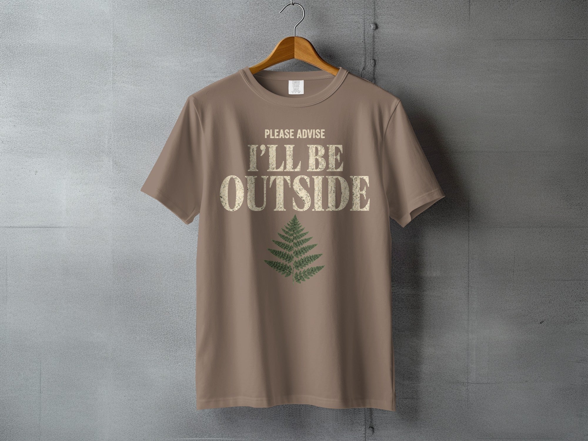 Brown t-shirt with "PLEASE ADVISE I'LL BE OUTSIDE" text and fern graphic.